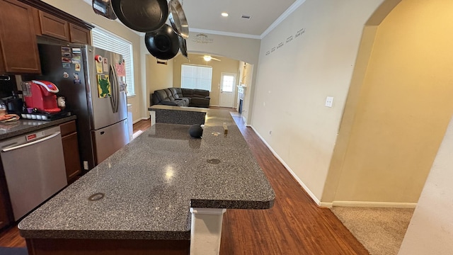 20530 Keegans Ledge Ln, Cypress, TX 77433 - kitchen with arched walkways, stainless steel appliances, dark wood finished floors, crown molding, and a ceiling fan
