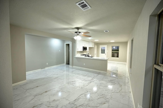 18927 Remington Bend Dr, Houston, TX 77073 - unfurnished living room with light marble finish floors, a ceiling fan, and a textured ceiling