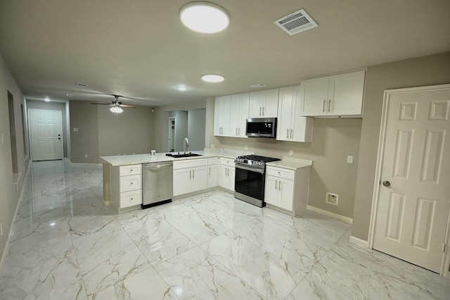 18927 Remington Bend Dr, Houston, TX 77073 - kitchen featuring appliances with stainless steel finishes, a peninsula, white cabinets, light marble finish flooring, and ceiling fan