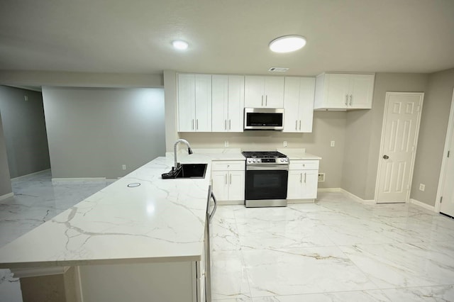 18927 Remington Bend Dr, Houston, TX 77073 - kitchen featuring appliances with stainless steel finishes, light stone counters, light marble finish floors, and white cabinetry