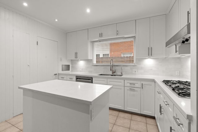 2409 Dryden Rd, Houston, TX 77030 - kitchen featuring appliances with stainless steel finishes, light tile patterned flooring, decorative backsplash, a kitchen island, and light countertops