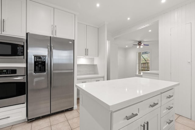 2409 Dryden Rd, Houston, TX 77030 - kitchen with appliances with stainless steel finishes, white cabinetry, ceiling fan, recessed lighting, and light tile patterned floors