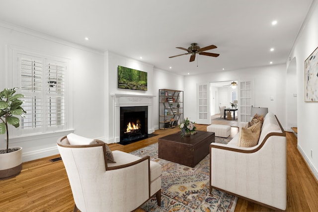 2409 Dryden Rd, Houston, TX 77030 - living room with ceiling fan, wood finished floors, a fireplace with flush hearth, recessed lighting, and ornamental molding