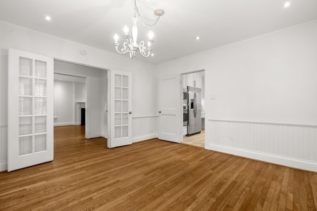 2409 Dryden Rd, Houston, TX 77030 - spare room featuring light wood finished floors, a chandelier, french doors, and recessed lighting