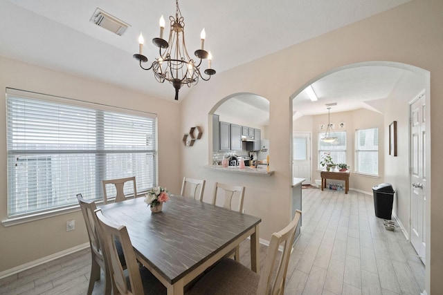 3261 Gladewater Ln, League City, TX 77573 - dining room featuring lofted ceiling, a chandelier, light wood-style flooring, and arched walkways