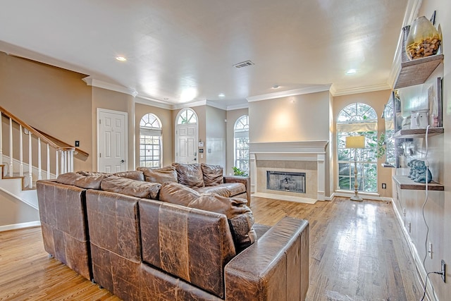 2315 Huldy St, Houston, TX 77019 - living area with light wood-type flooring, crown molding, stairs, plenty of natural light, and a tile fireplace