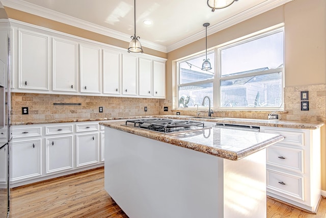 2315 Huldy St, Houston, TX 77019 - kitchen with stainless steel gas cooktop, white cabinets, crown molding, and a kitchen island