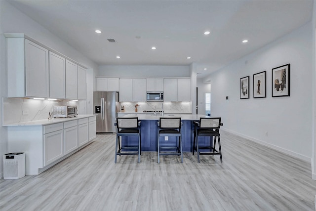3368 Voda Bend Dr, Katy, TX 77493 - kitchen with stainless steel appliances, white cabinetry, light wood-style flooring, and recessed lighting