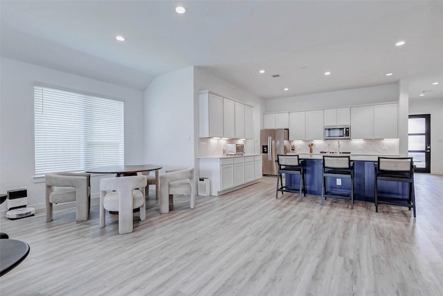 3368 Voda Bend Dr, Katy, TX 77493 - kitchen featuring stainless steel appliances, light wood-type flooring, tasteful backsplash, and recessed lighting