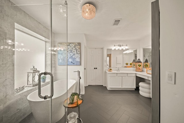 3803 Caleb Ln, Missouri City, TX 77459 - bathroom featuring vanity, a freestanding tub, and a chandelier