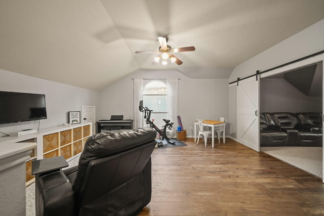 3803 Caleb Ln, Missouri City, TX 77459 - living area featuring a barn door, ceiling fan, hardwood / wood-style flooring, vaulted ceiling, and a textured ceiling