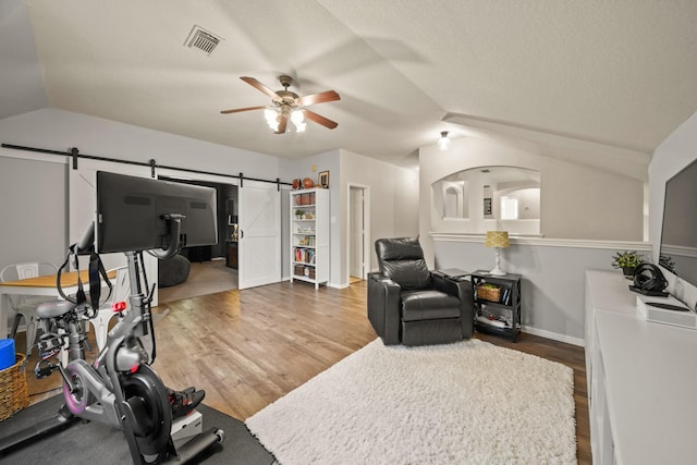 3803 Caleb Ln, Missouri City, TX 77459 - workout room with lofted ceiling, a barn door, ceiling fan, and wood finished floors