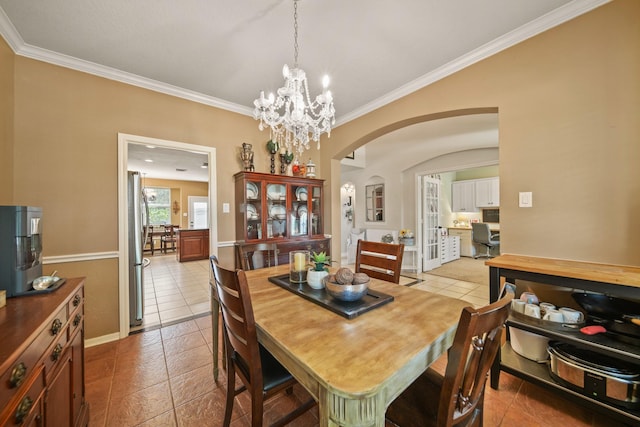 3803 Caleb Ln, Missouri City, TX 77459 - dining area featuring arched walkways, crown molding, light tile patterned floors, and a chandelier