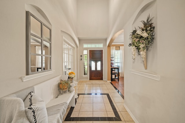 3803 Caleb Ln, Missouri City, TX 77459 - entrance foyer featuring light tile patterned floors, inlaid floor details, arched walkways, and a towering ceiling