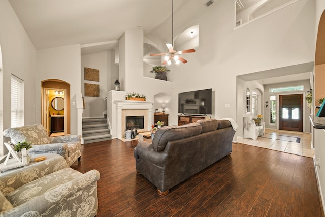 3803 Caleb Ln, Missouri City, TX 77459 - living room with high vaulted ceiling, wood-type flooring, a ceiling fan, arched walkways, and a tile fireplace