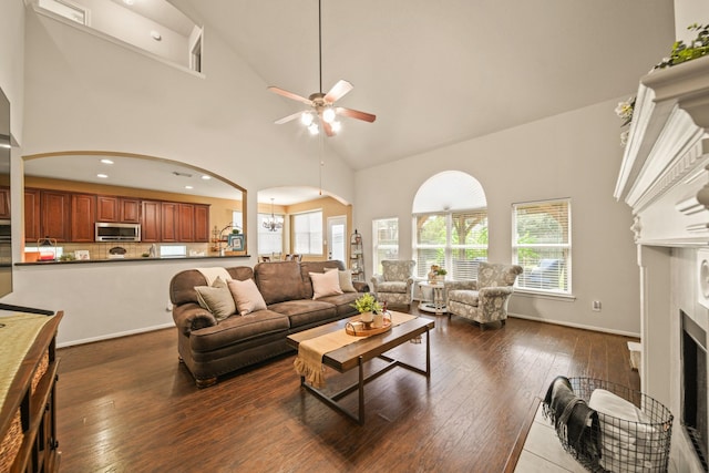 3803 Caleb Ln, Missouri City, TX 77459 - living area featuring arched walkways, high vaulted ceiling, ceiling fan, dark wood-type flooring, and a fireplace
