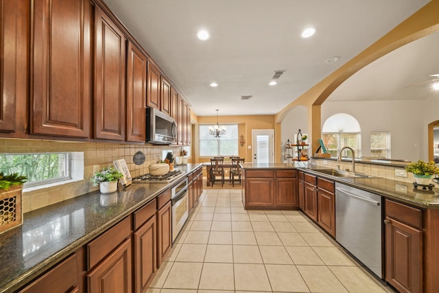 3803 Caleb Ln, Missouri City, TX 77459 - kitchen with stainless steel appliances, tasteful backsplash, light tile patterned flooring, arched walkways, and recessed lighting