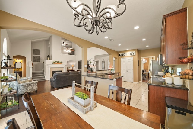 3803 Caleb Ln, Missouri City, TX 77459 - dining space with light tile patterned floors, arched walkways, recessed lighting, a fireplace, and ceiling fan