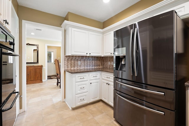 2101 Rocky Creek Ln, Pearland, TX 77581 - kitchen with fridge with ice dispenser, white cabinetry, tasteful backsplash, dark stone counters, and recessed lighting