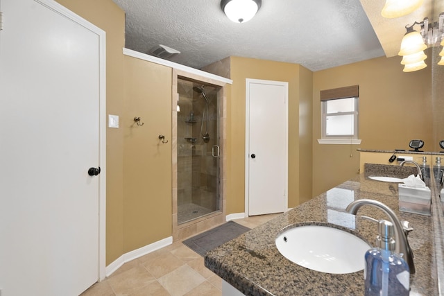 2101 Rocky Creek Ln, Pearland, TX 77581 - full bathroom with a textured ceiling, a shower stall, double vanity, and tile patterned flooring