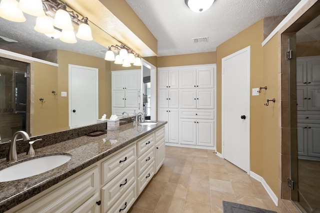 2101 Rocky Creek Ln, Pearland, TX 77581 - full bathroom featuring double vanity, a stall shower, and a textured ceiling