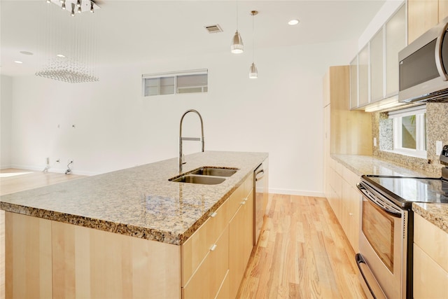 2232 Leeland St, Houston, TX 77003 - kitchen featuring appliances with stainless steel finishes, light brown cabinets, modern cabinets, and recessed lighting