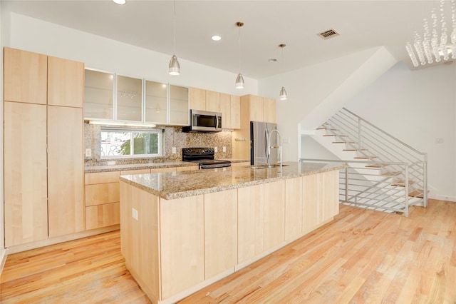 2232 Leeland St, Houston, TX 77003 - kitchen with light brown cabinetry, stainless steel appliances, light wood-style floors, a large island, and tasteful backsplash