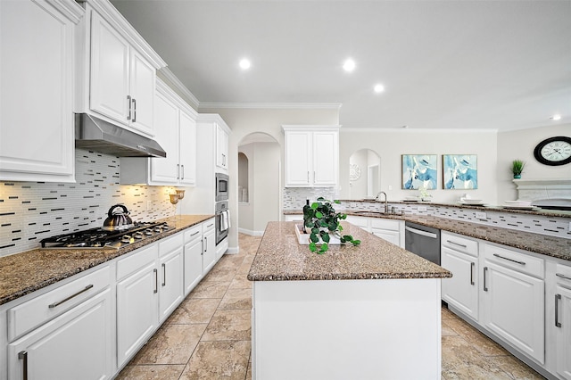 27910 Wedgeoak Ct, Katy, TX 77494 - kitchen featuring stainless steel appliances, arched walkways, under cabinet range hood, ornamental molding, and a center island