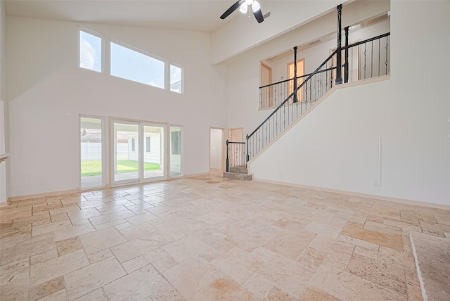 982 W Donovan St, Houston, TX 77091 - unfurnished living room with stone tile flooring, high vaulted ceiling, healthy amount of natural light, ceiling fan, and stairway