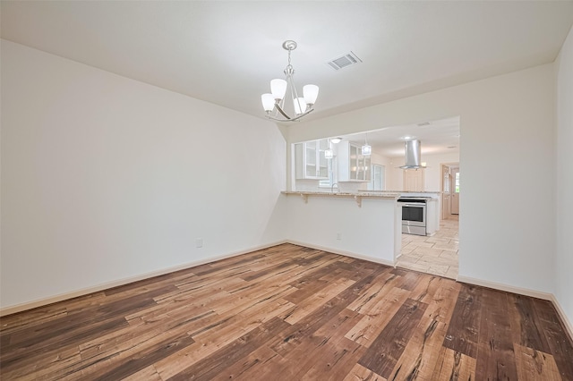 982 W Donovan St, Houston, TX 77091 - unfurnished living room with light wood-style flooring and a chandelier