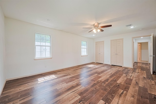 982 W Donovan St, Houston, TX 77091 - unfurnished bedroom featuring two closets, multiple windows, wood-type flooring, and recessed lighting