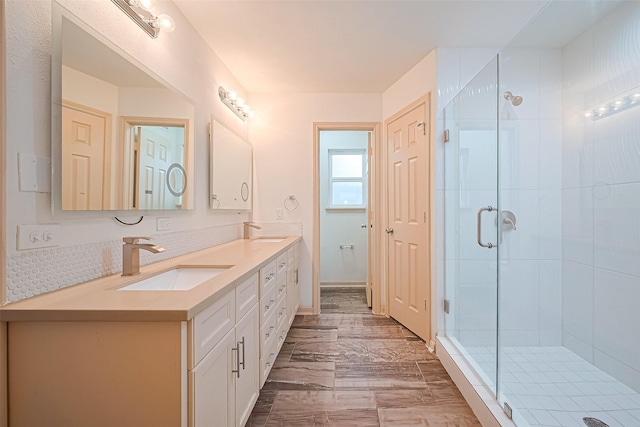 982 W Donovan St, Houston, TX 77091 - bathroom with double vanity, a shower stall, marble look tiles, and backsplash