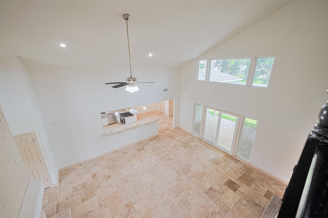 982 W Donovan St, Houston, TX 77091 - unfurnished living room with high vaulted ceiling, stone tile floors, recessed lighting, and ceiling fan