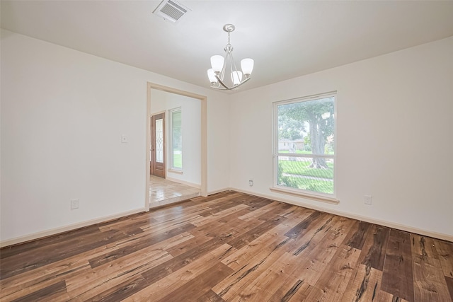 982 W Donovan St, Houston, TX 77091 - unfurnished room featuring a chandelier, wood-type flooring, and healthy amount of natural light