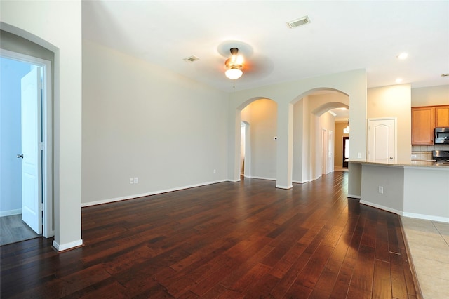 8022 Thorncroft Manor Ln, Richmond, TX 77407 - unfurnished living room featuring dark wood-style floors, arched walkways, recessed lighting, and ceiling fan
