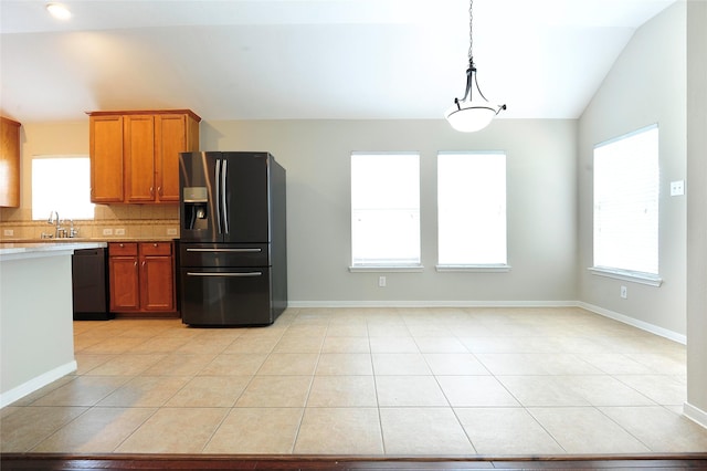 8022 Thorncroft Manor Ln, Richmond, TX 77407 - kitchen with stainless steel fridge, vaulted ceiling, black dishwasher, brown cabinets, and light countertops