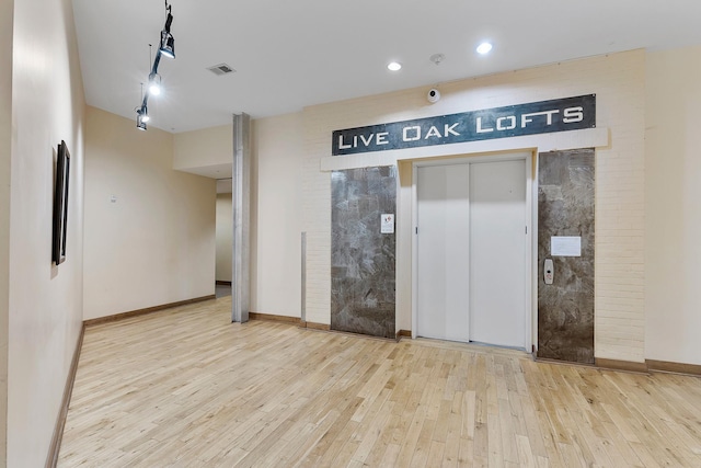 1312 Live Oak St Unit 215, Houston, TX 77003 - unfurnished room featuring hardwood / wood-style flooring, rail lighting, elevator, recessed lighting, and a pendent fire sprinkler