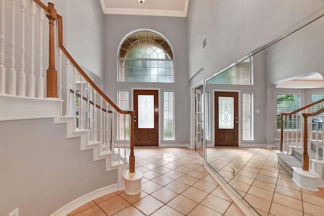 15510 Marble Canyon Way, Houston, TX 77044 - foyer with stairway, light tile patterned floors, a towering ceiling, crown molding, and arched walkways
