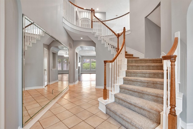 15510 Marble Canyon Way, Houston, TX 77044 - foyer entrance with light tile patterned flooring, stairway, arched walkways, and a high ceiling