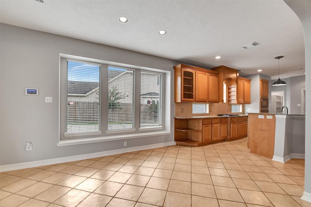 15510 Marble Canyon Way, Houston, TX 77044 - kitchen with built in microwave, brown cabinetry, recessed lighting, decorative backsplash, and light tile patterned floors