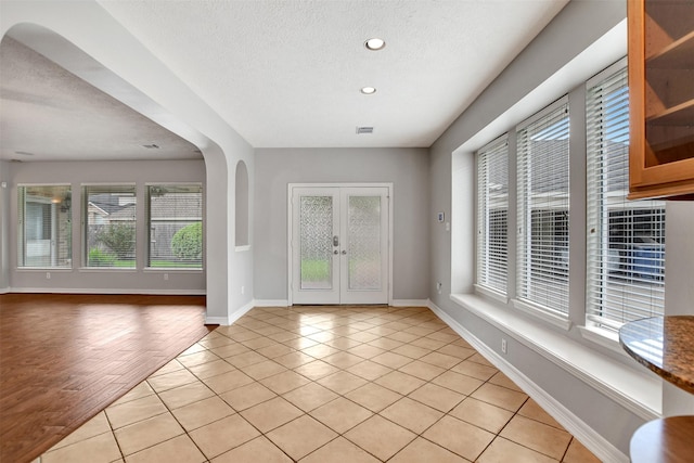 15510 Marble Canyon Way, Houston, TX 77044 - spare room featuring healthy amount of natural light, french doors, a textured ceiling, light tile patterned flooring, and recessed lighting