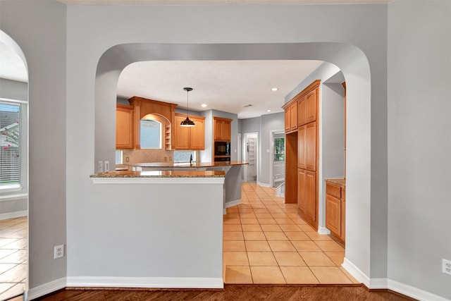 15510 Marble Canyon Way, Houston, TX 77044 - kitchen featuring black microwave, a peninsula, dark stone countertops, decorative backsplash, and healthy amount of natural light