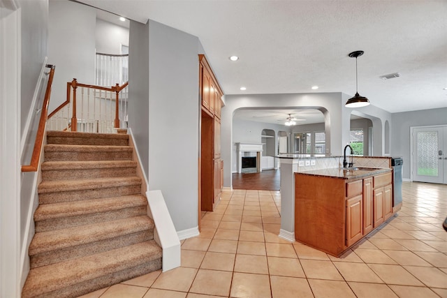 15510 Marble Canyon Way, Houston, TX 77044 - kitchen featuring light tile patterned floors, arched walkways, open floor plan, ceiling fan, and recessed lighting