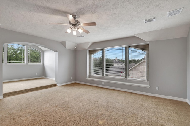 15510 Marble Canyon Way, Houston, TX 77044 - carpeted spare room with plenty of natural light, a textured ceiling, a ceiling fan, and arched walkways
