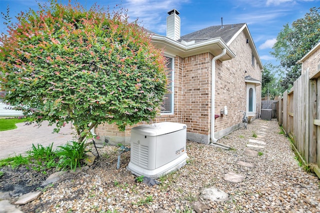 15510 Marble Canyon Way, Houston, TX 77044 - view of side of home featuring brick siding, a fenced backyard, and a chimney