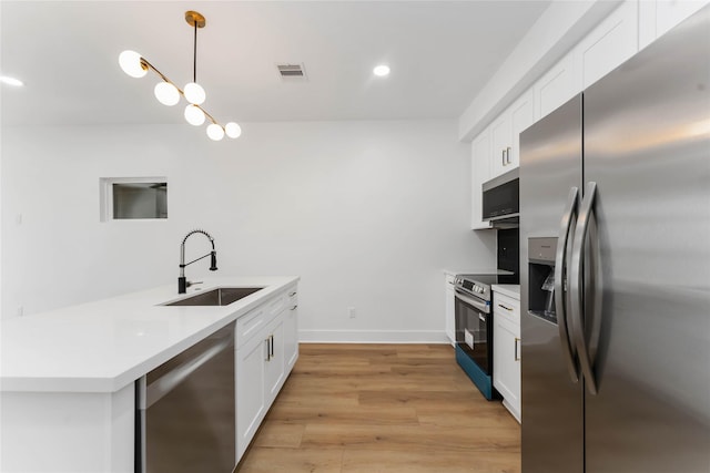 3327 Cornell St Unit A B, Houston, TX 77022 - kitchen with stainless steel appliances, white cabinetry, hanging light fixtures, light countertops, and recessed lighting