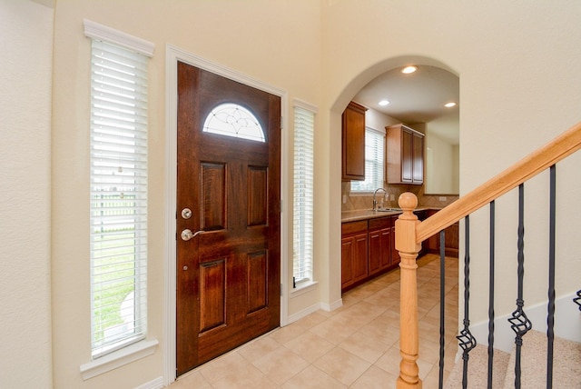 18702 Cypress Loch Dr, Spring, TX 77379 - entryway featuring light tile patterned floors, arched walkways, stairs, and recessed lighting