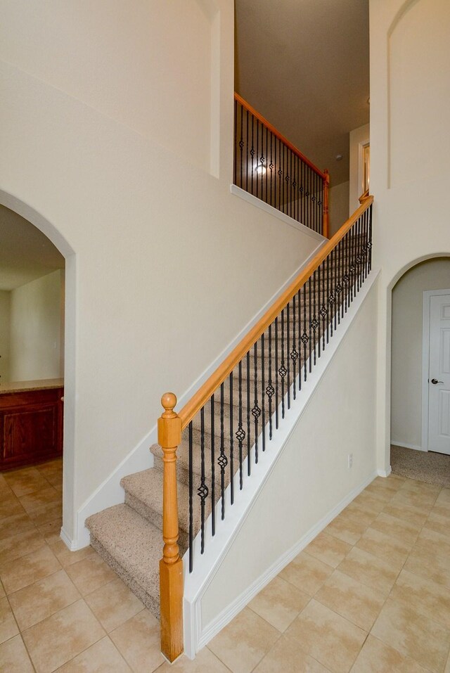 18702 Cypress Loch Dr, Spring, TX 77379 - stairs with arched walkways, tile patterned flooring, and a high ceiling