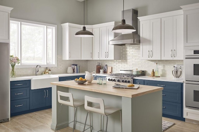 0000 Marina Blvd, Galveston, TX 77554 - kitchen featuring blue cabinetry, wood counters, stainless steel appliances, and a kitchen island