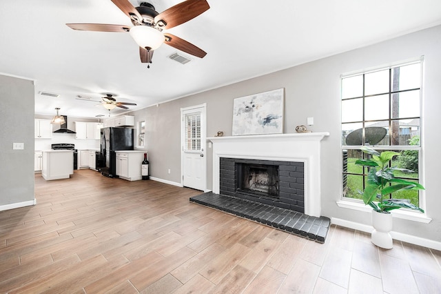 17203 Kettle Creek Dr, Spring, TX 77379 - unfurnished living room with a ceiling fan, light wood-type flooring, and a fireplace